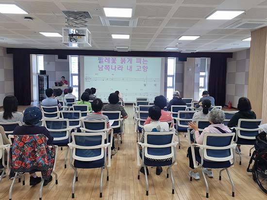 교실에서 강사에게서 노래연습을 받고 있는 수강생 모습 